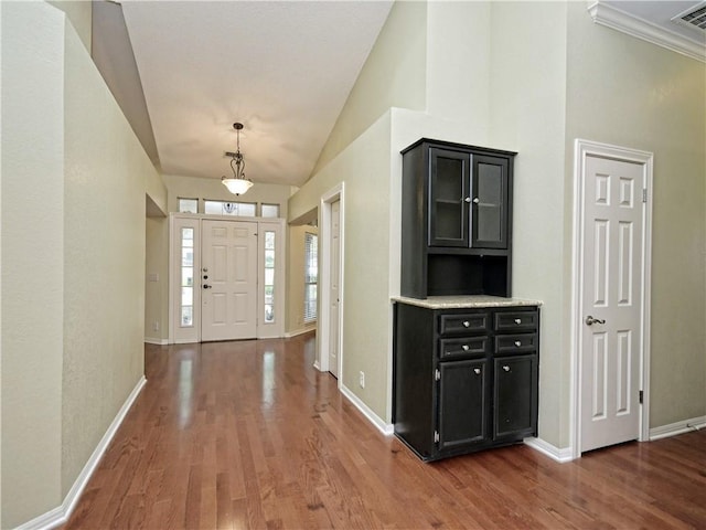 entryway with wood-type flooring and vaulted ceiling