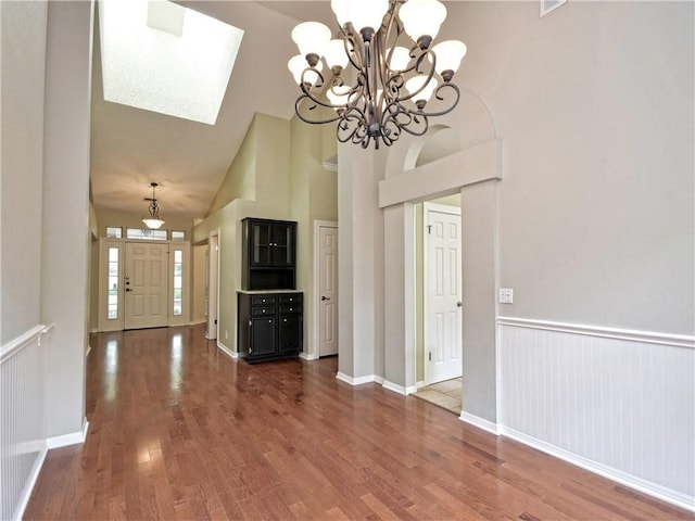 entrance foyer with high vaulted ceiling and dark hardwood / wood-style flooring