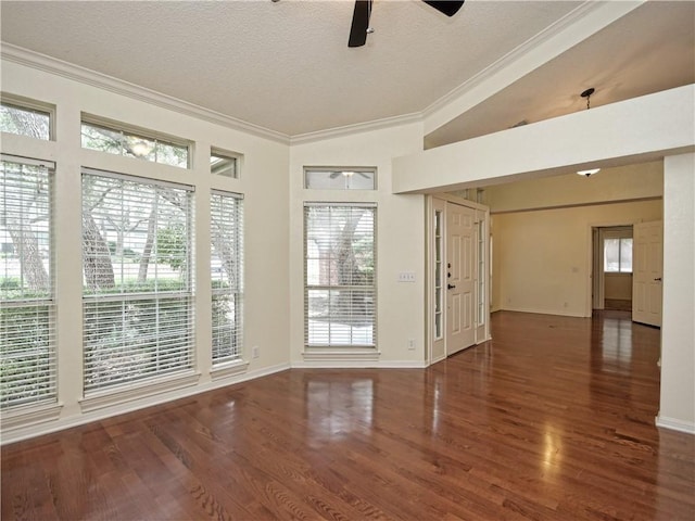 empty room featuring ornamental molding, a textured ceiling, ceiling fan, and dark hardwood / wood-style flooring