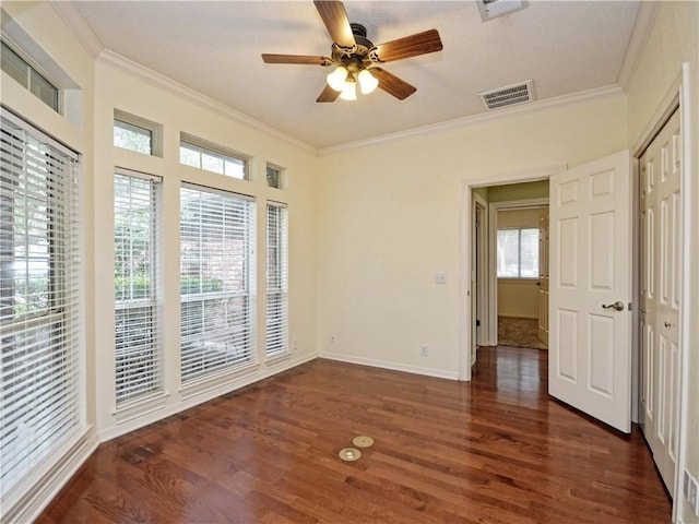 spare room with ceiling fan, ornamental molding, and dark wood-type flooring