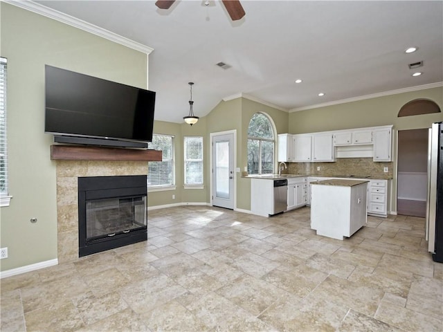 kitchen with a center island, tasteful backsplash, white cabinetry, pendant lighting, and stainless steel appliances