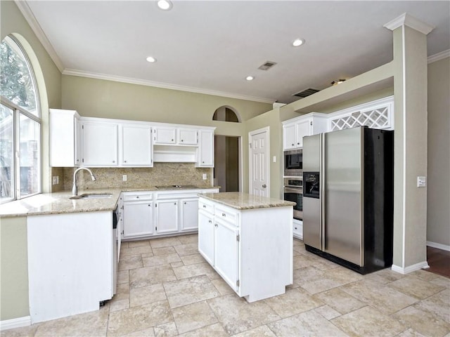 kitchen featuring tasteful backsplash, white cabinetry, sink, a kitchen island, and stainless steel appliances