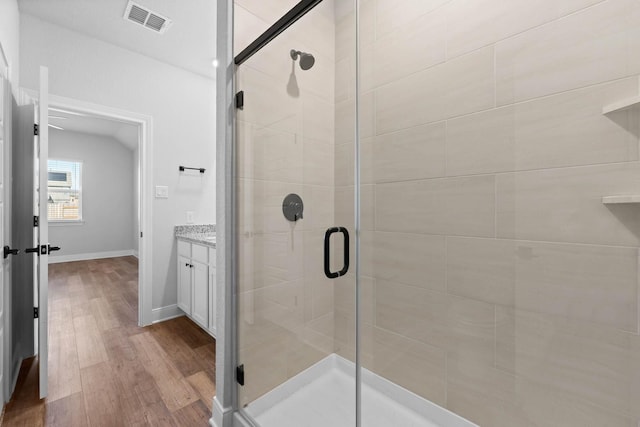 bathroom with vanity, hardwood / wood-style floors, and a shower with door