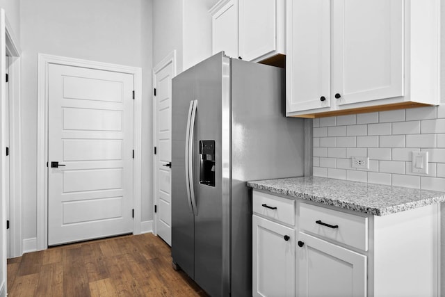 kitchen featuring stainless steel fridge with ice dispenser, white cabinetry, dark hardwood / wood-style floors, tasteful backsplash, and light stone countertops