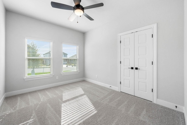 unfurnished room featuring ceiling fan and light colored carpet