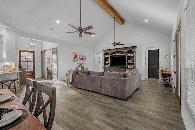 living room featuring a barn door, dark hardwood / wood-style floors, high vaulted ceiling, and beam ceiling