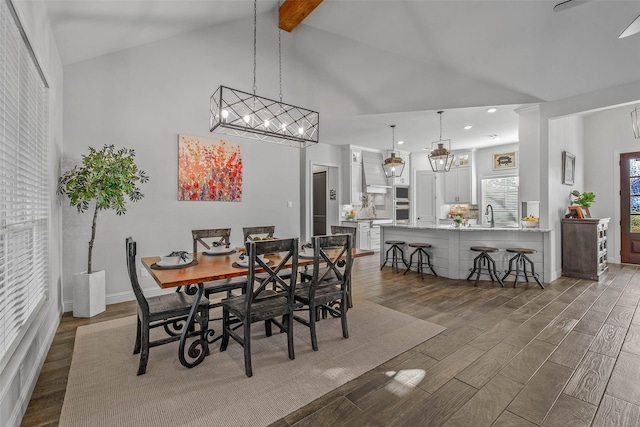 dining area with dark wood-type flooring, sink, beam ceiling, and high vaulted ceiling