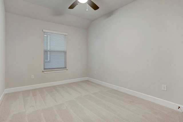 carpeted spare room featuring vaulted ceiling and ceiling fan