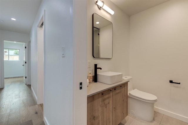 bathroom featuring hardwood / wood-style flooring, toilet, and vanity