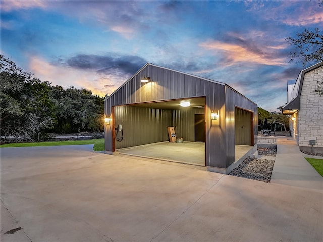 property exterior at dusk with an outdoor structure and a garage