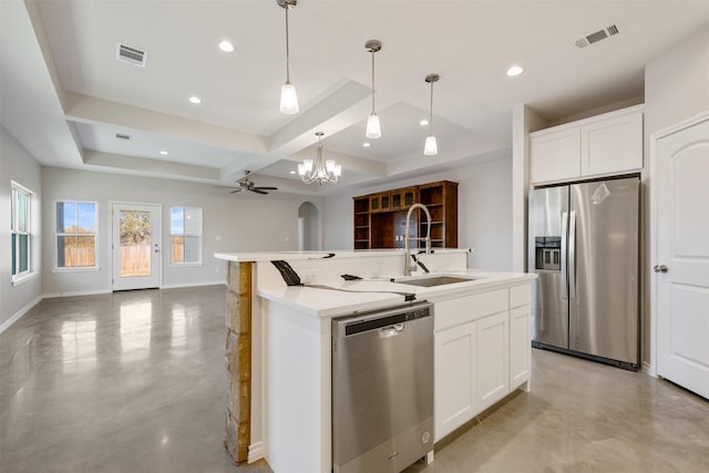 kitchen featuring pendant lighting, a center island with sink, sink, white cabinetry, and stainless steel appliances