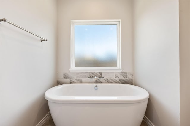 bathroom featuring plenty of natural light and a tub