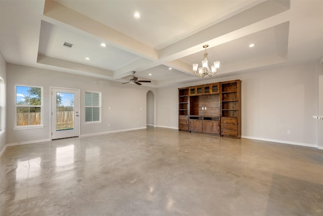 unfurnished living room with ceiling fan with notable chandelier and a tray ceiling