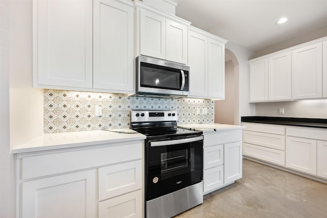 kitchen with stainless steel appliances, decorative backsplash, and white cabinetry