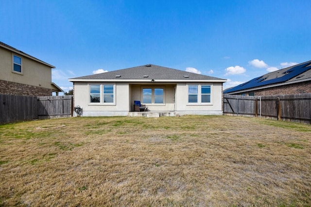 rear view of property featuring a lawn