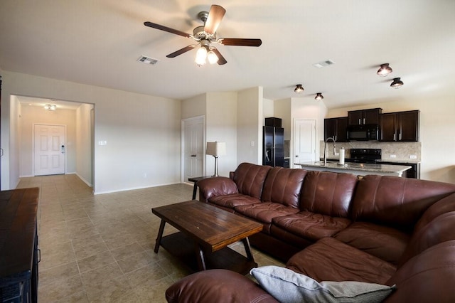 living room with ceiling fan and sink