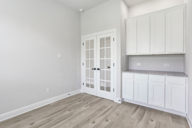 unfurnished dining area with light hardwood / wood-style flooring and french doors