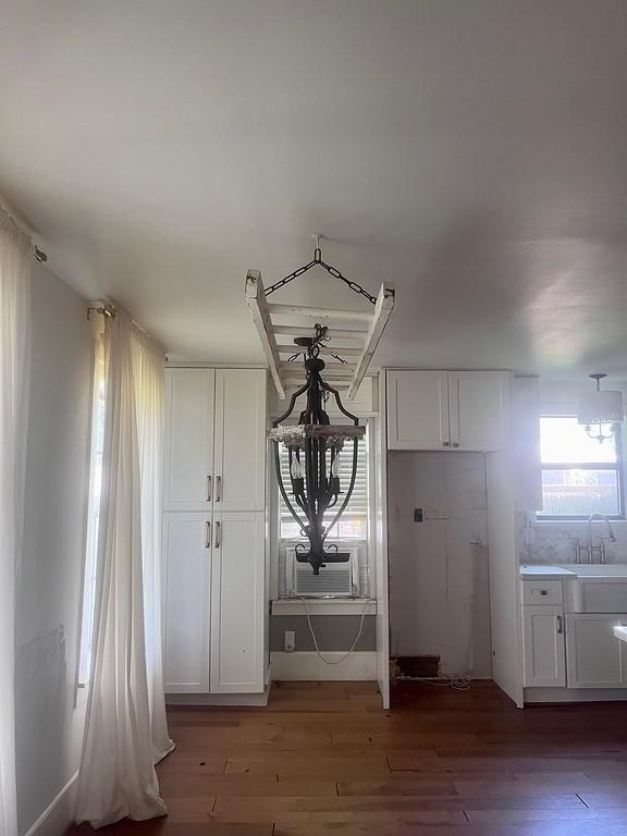 interior space with cooling unit, hardwood / wood-style flooring, and sink