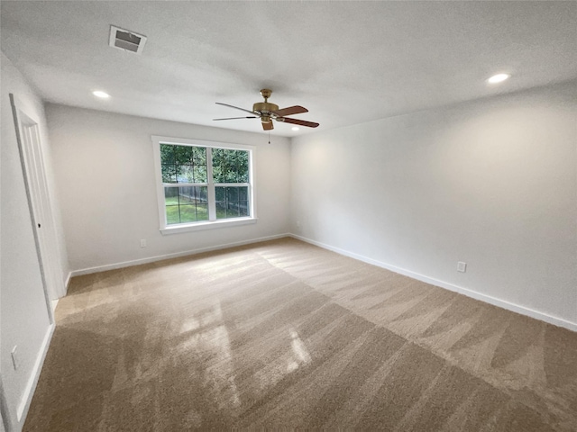 spare room featuring a textured ceiling, carpet floors, and ceiling fan