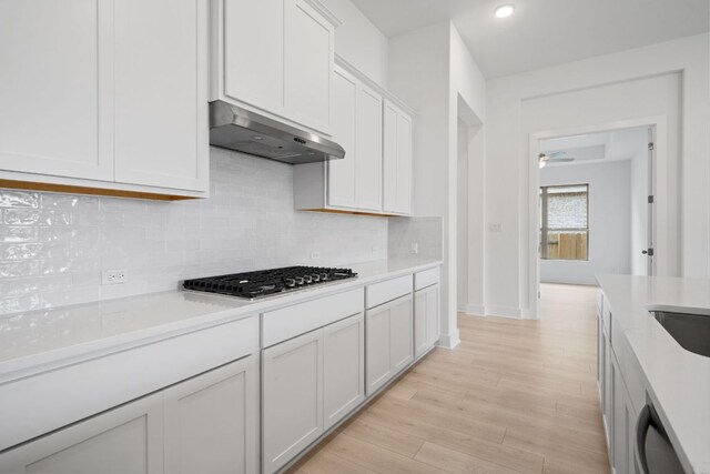 295 Five Mile Creek Way, Kyle, TX 78640 - kitchen with ventilation hood, stainless steel gas cooktop, light countertops, backsplash, and dishwashing machine