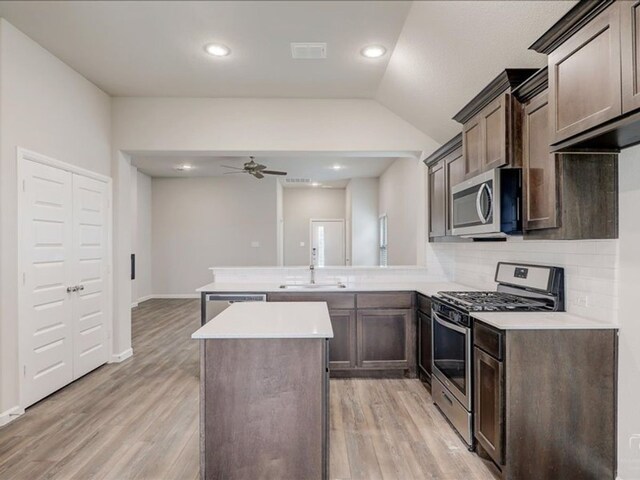 212 Hidalgo Ln, Elgin, TX 78621 - kitchen featuring appliances with stainless steel finishes, a sink, a peninsula, a ceiling fan, and light countertops