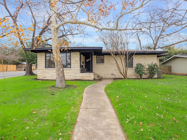 ranch-style home with a front yard and central air condition unit