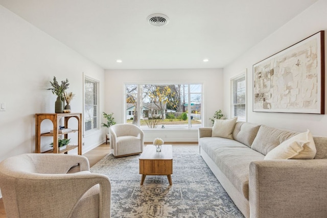 living area with recessed lighting, visible vents, and wood finished floors