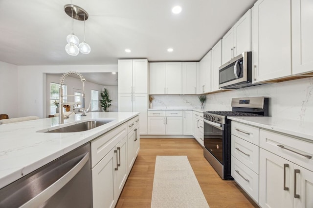 kitchen featuring white cabinets, recessed lighting, appliances with stainless steel finishes, and a sink