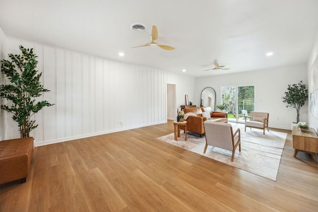 living area featuring visible vents, a decorative wall, recessed lighting, a ceiling fan, and light wood-style flooring