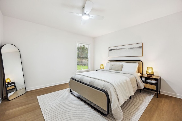 bedroom with baseboards, ceiling fan, and wood finished floors