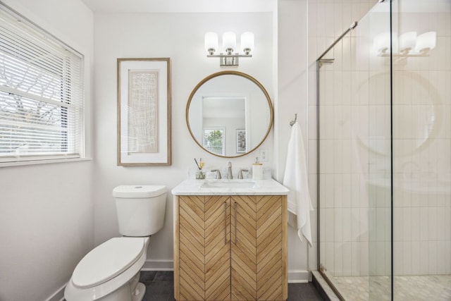 full bathroom featuring vanity, baseboards, toilet, and a shower stall