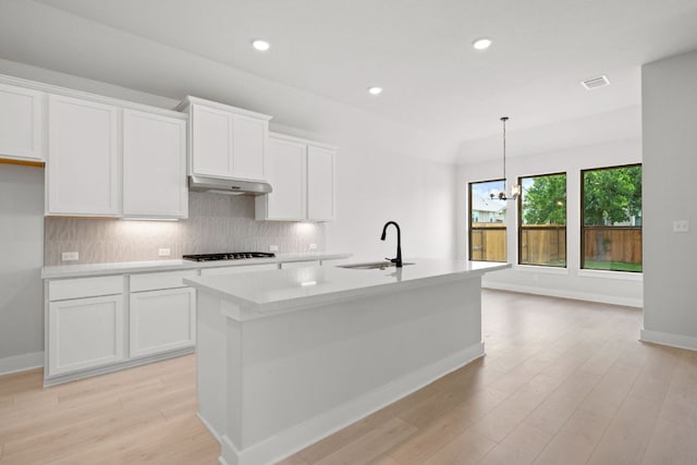 314 Five Mile Creek Way, Kyle, TX 78640 - kitchen with a sink, gas cooktop, tasteful backsplash, light countertops, and white cabinets