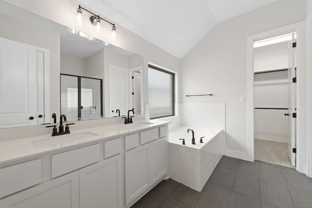314 Five Mile Creek Way, Kyle, TX 78640 - bathroom with a stall shower, a bath, a walk in closet, vaulted ceiling, and double vanity