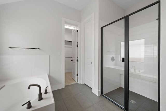 314 Five Mile Creek Way, Kyle, TX 78640 - full bathroom featuring a garden tub, a shower stall, a walk in closet, and tile patterned floors