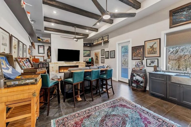 bar featuring ceiling fan, dark tile patterned flooring, and beam ceiling