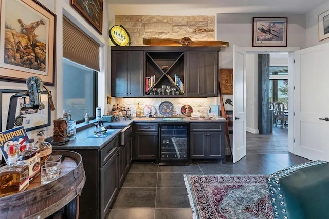 bar featuring decorative backsplash, beverage cooler, dark tile patterned flooring, and sink