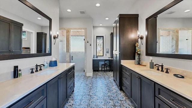 bathroom featuring a shower with door and vanity