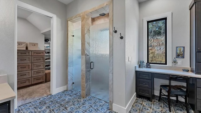 bathroom with a shower with shower door, vanity, and lofted ceiling