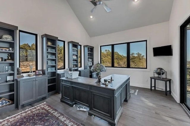 office area featuring light wood-type flooring, ceiling fan, and high vaulted ceiling