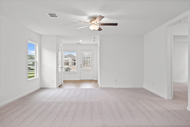 carpeted spare room featuring ceiling fan