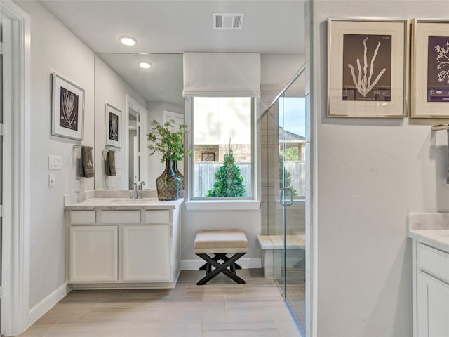 bathroom with a shower with shower door, tile patterned floors, and vanity