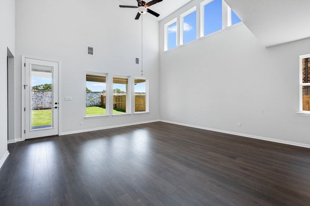 184 Milam Creek Dr, Kyle, TX 78640 - unfurnished living room featuring ceiling fan, a towering ceiling, baseboards, and dark wood-type flooring