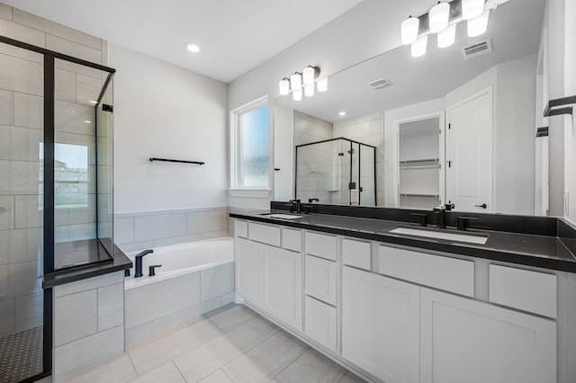 184 Milam Creek Dr, Kyle, TX 78640 - full bathroom featuring a stall shower, double vanity, a bath, tile patterned floors, and a spacious closet