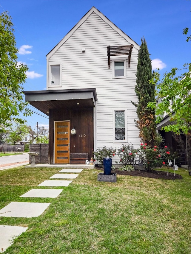 rear view of property featuring a lawn