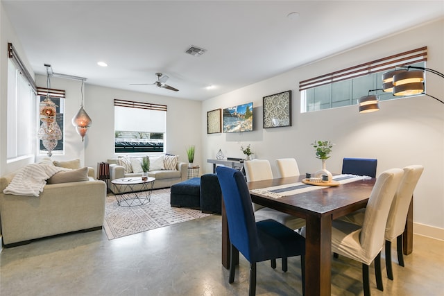 dining area featuring ceiling fan and concrete floors