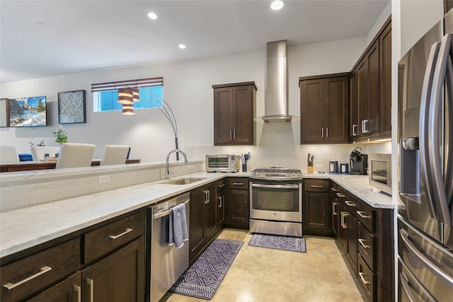 kitchen featuring sink, wall chimney range hood, stainless steel appliances, and dark brown cabinetry