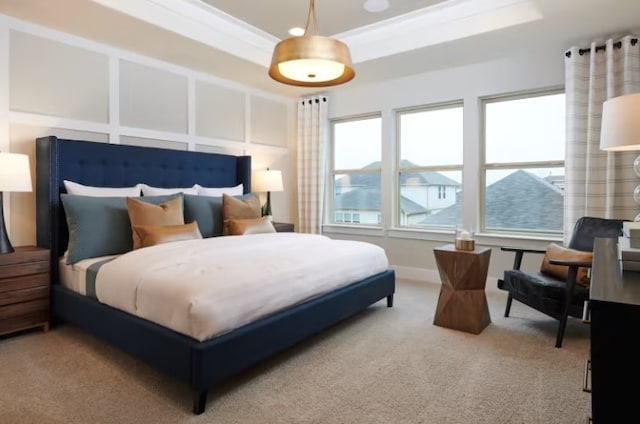 bedroom featuring carpet, ornamental molding, and a tray ceiling