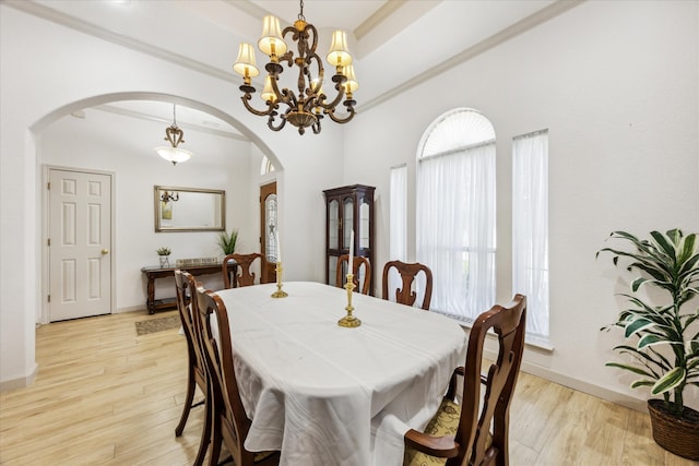 dining area featuring crown molding, a notable chandelier, and light wood-type flooring