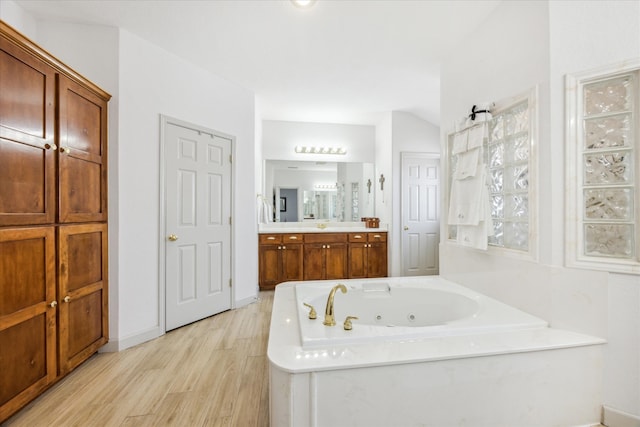 bathroom with vanity, hardwood / wood-style floors, and a washtub