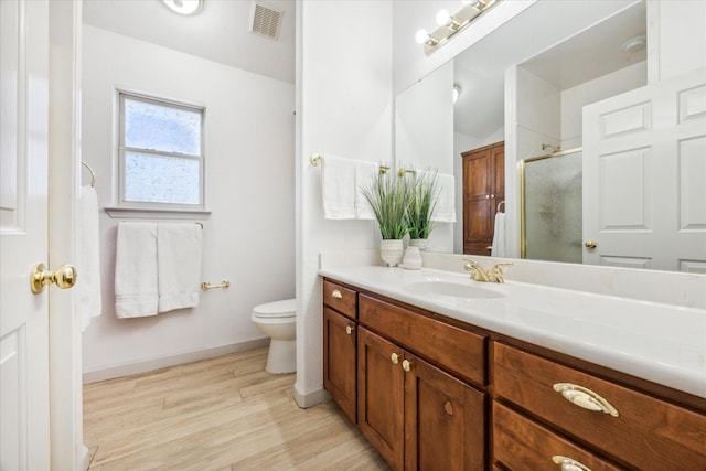 bathroom with vanity, hardwood / wood-style floors, toilet, and walk in shower